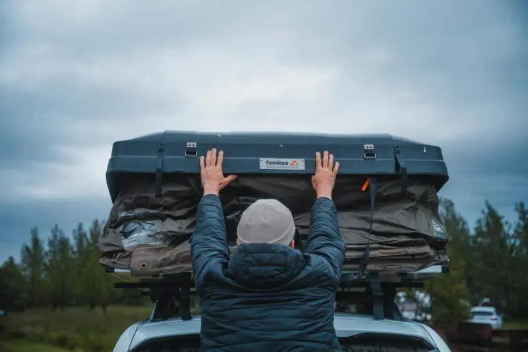 person opening a rooftop tent on a car in Iceland